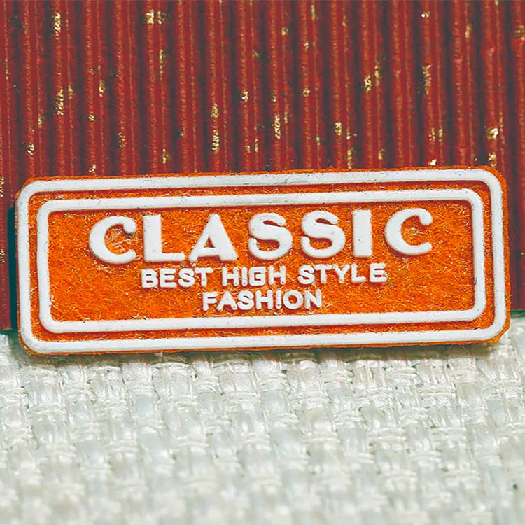 Orange rectangular brand patch with a raised border and contrasting lettering