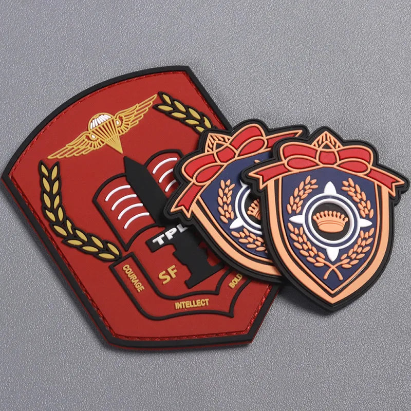 Red and black shield-shaped logo patches with raised emblems