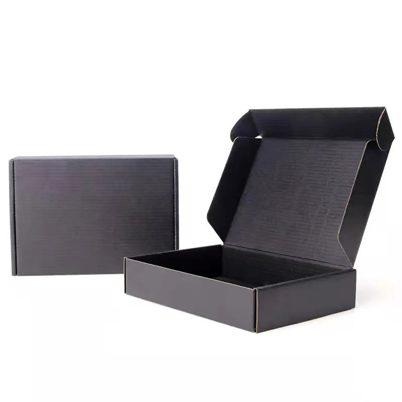 Open and closed plain black corrugated mailer boxes on a white background