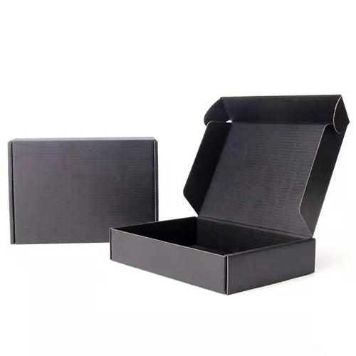 Open and closed plain black corrugated mailer boxes on a white background