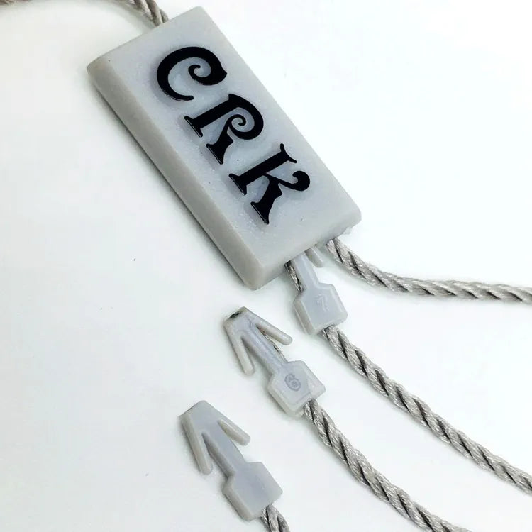 White rectangular plastic string tag with grey twisted cords and plastic arrow barb fasteners