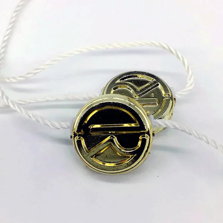 Round gold-tone snap-style button seals with white twisted cords