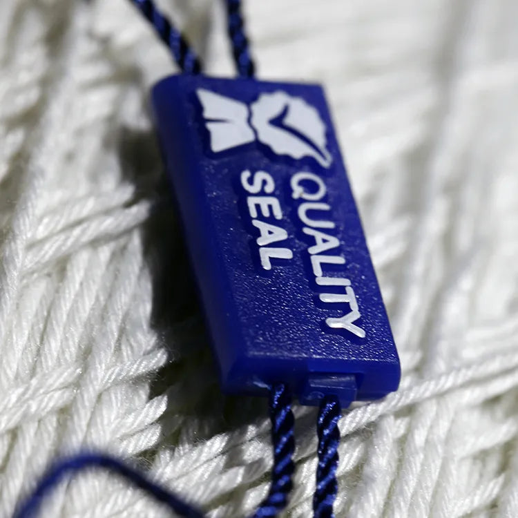 Blue rectangular plastic seal tag angled closeup with navy twisted cords