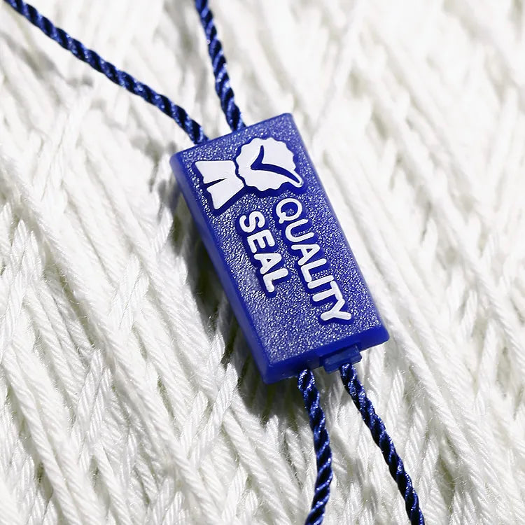 Blue rectangular plastic seal tag with navy twisted cords on white knit fabric