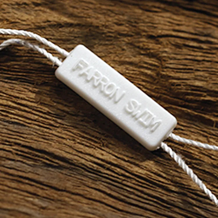 White rectangular plastic string tag with debossed lettering and white twisted cords