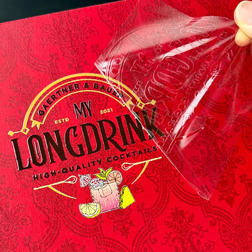 Full-color packaging graphic on a red surface with clear carrier film