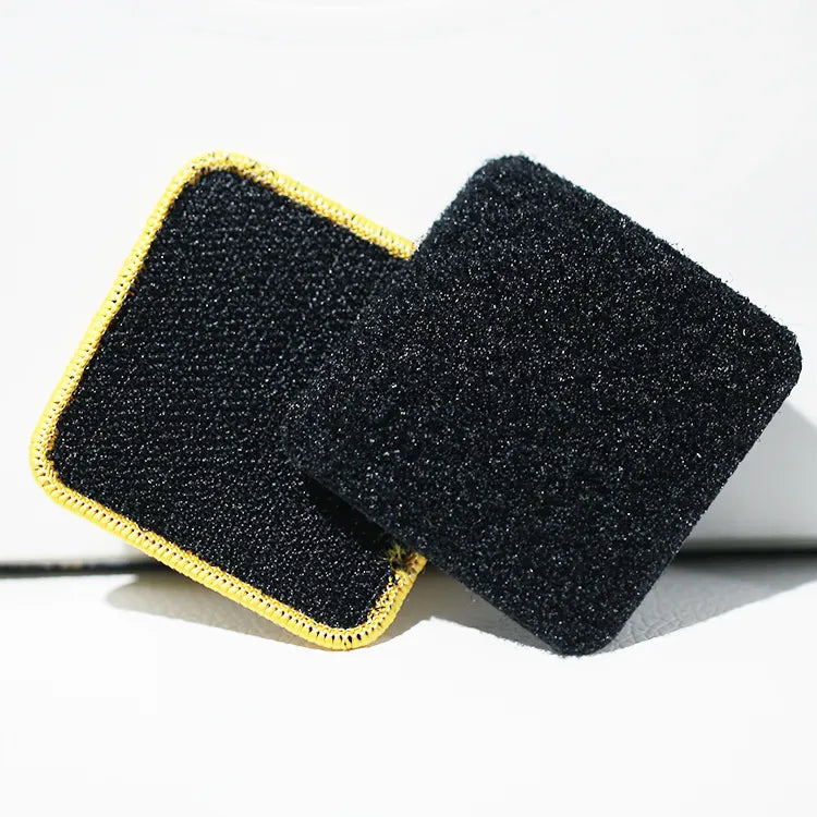 Close-up of black hook-and-loop backing for custom embroidered patches with yellow stitched border