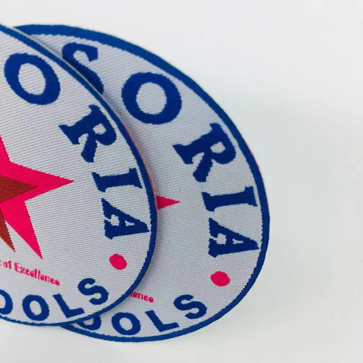 Close-up of overlapping white and blue circular embroidered school patches with red star accents