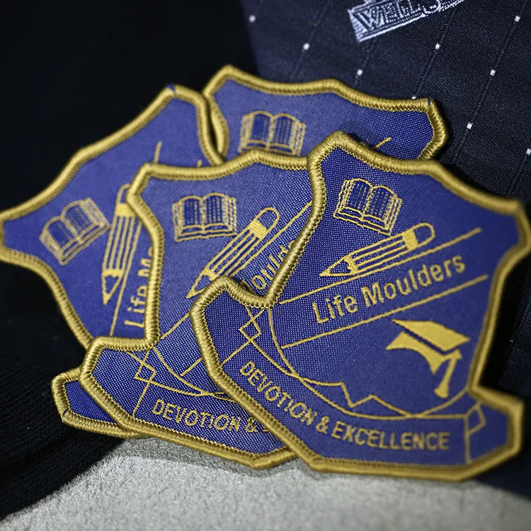 Blue and yellow school crest patches with lettering and decorative outlines