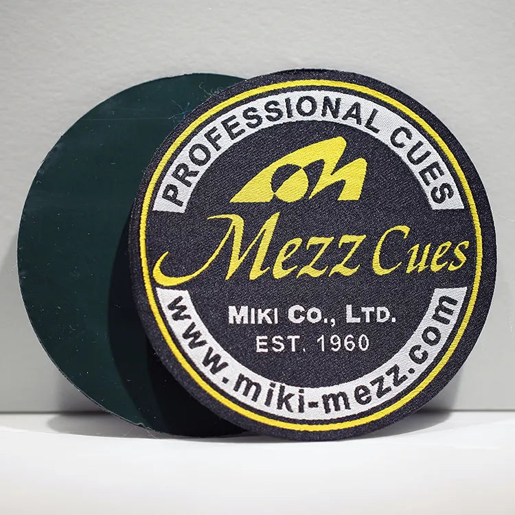 Round black and gold logo badge shown with a dark backing layer