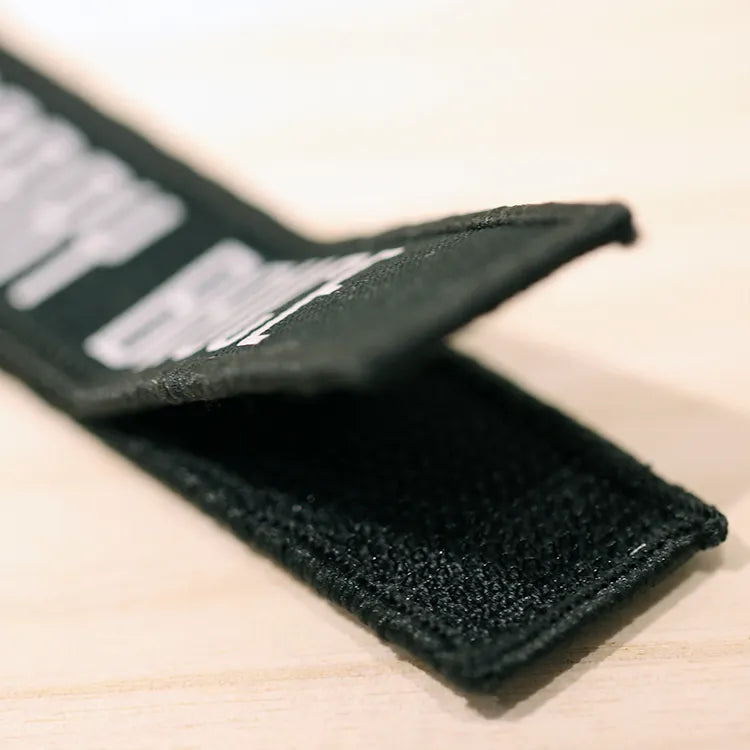 Close-up of black hook-and-loop backing attached to a custom woven label patch