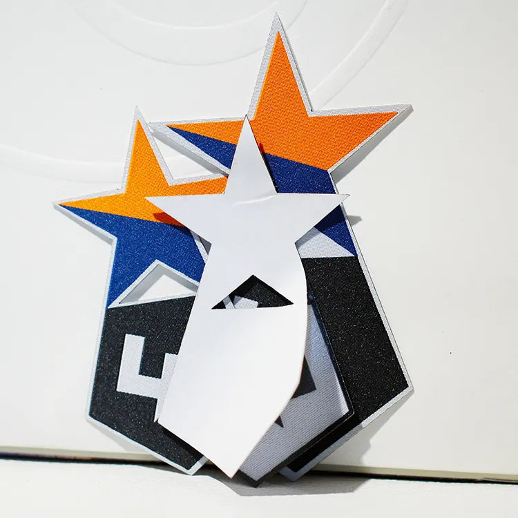 Colorful layered embroidered star-shaped patch in orange, blue, black, and white