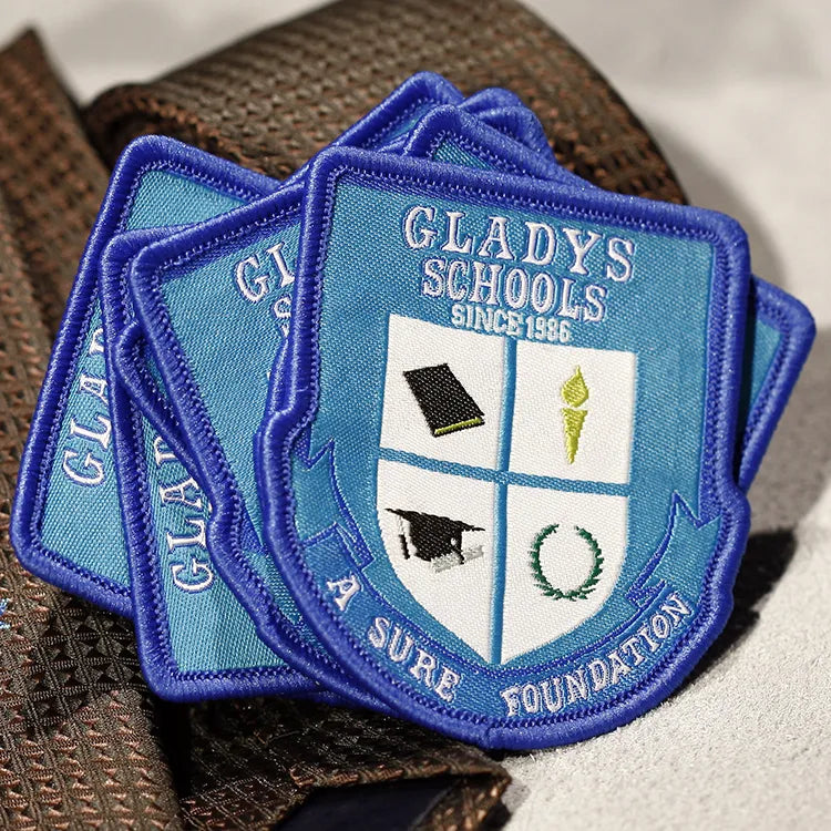 Custom blue embroidered school crest patch with four-section emblem and Gladys Schools lettering