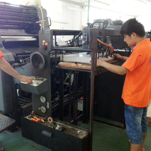 Operator working beside printing press rollers