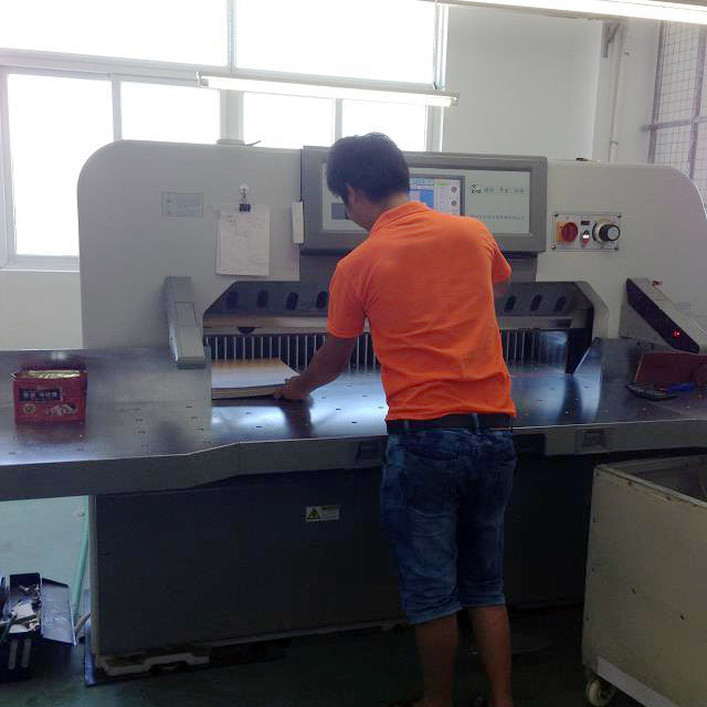 Operator working with sheets at production equipment