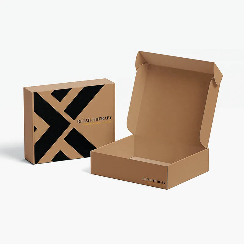 Open and closed kraft mailer boxes with black geometric printing and Retail Therapy branding