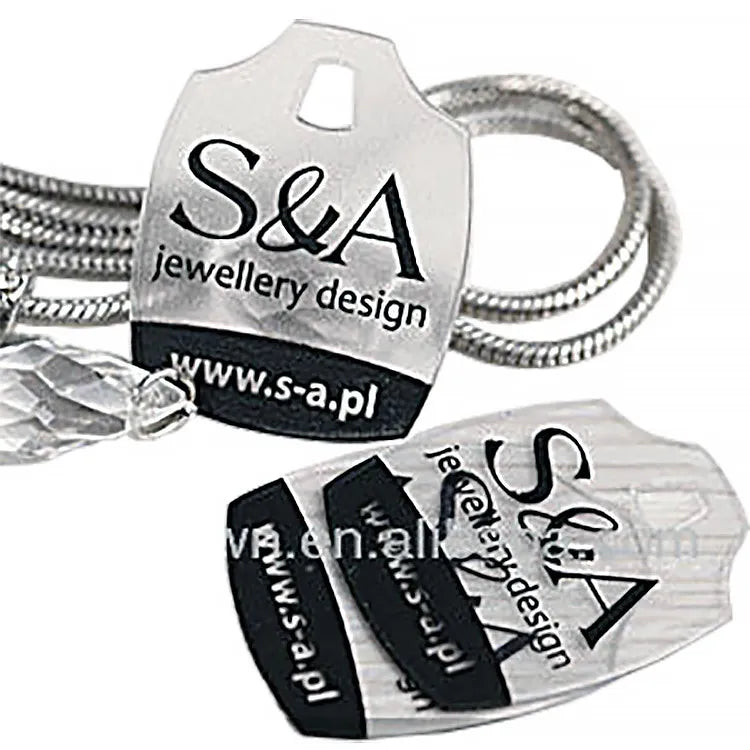 Shield-shaped clear plastic jewelry card mounted on silver snake chain necklace with sparkling faceted crystal pendant