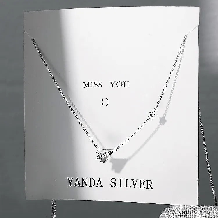 White cardstock necklace holder card showing chain slit placement and pendant hanging