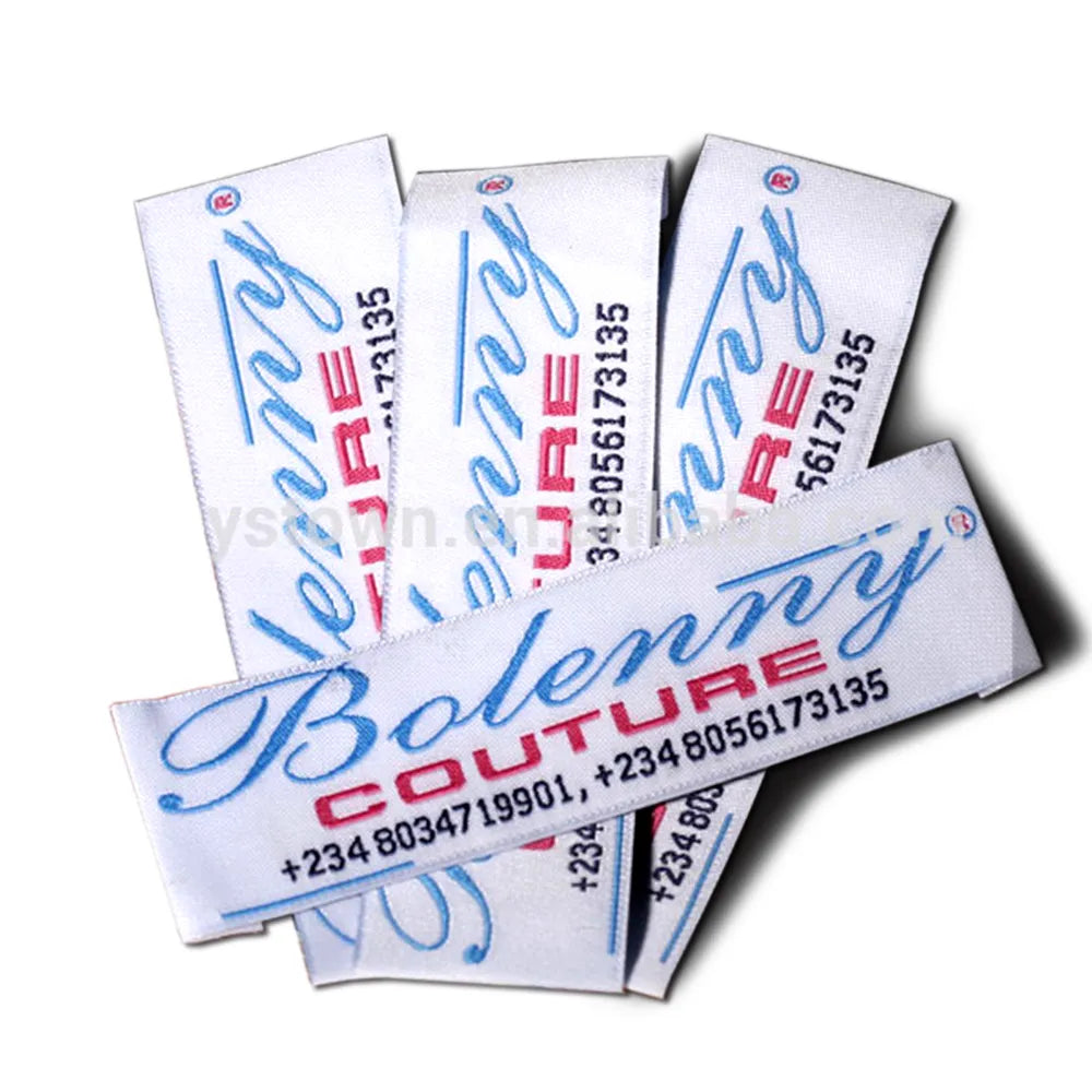 White woven clothing label with blue Bolenmy Couture script wordmark, registered trademark symbol and contact numbers