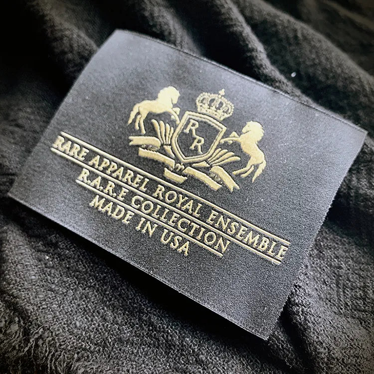 Black woven clothing label with gold crest and Made in USA text