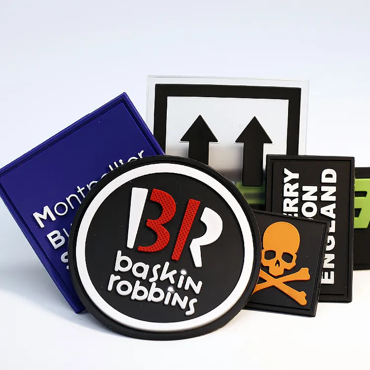 Collection of custom multi-color drip-molded PVC rubber patches including round brand logos and skull emblems
